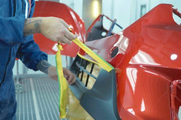 Auto body paint technician removing tape from masked off grille | Parkville Auto Body